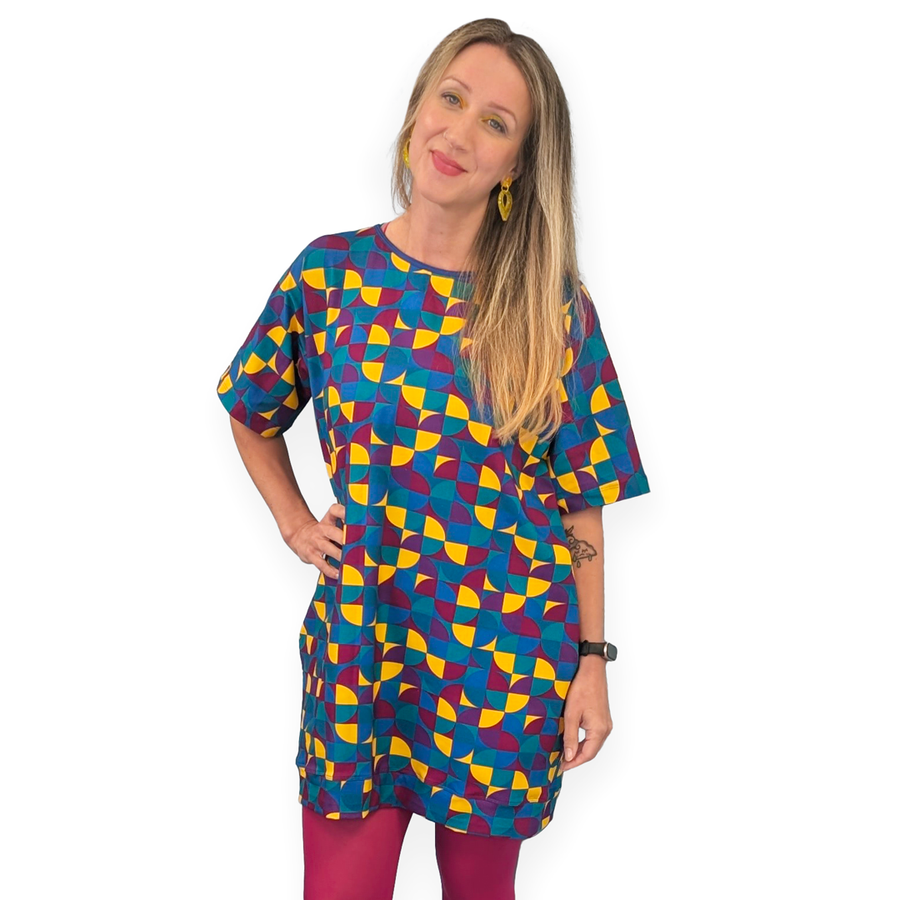 Ros wearing a cotton tunic style dress in Eclipse fabric with dark pink tights.